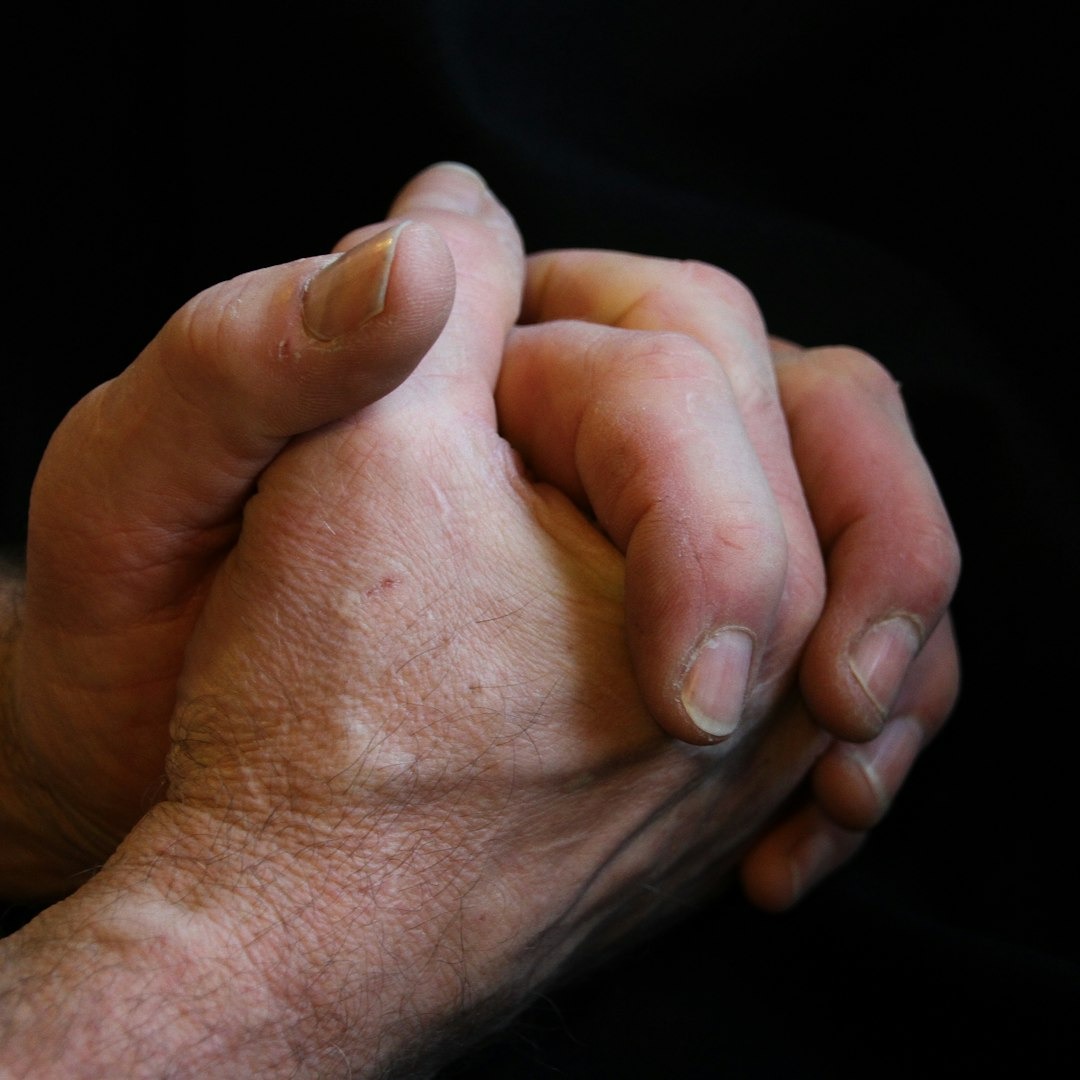 Two hands clasped together in a gesture of contemplation.